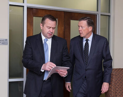 Bob Sexton y Mike Rainwater saliendo de una sala de audiencias tras discutir estrategias.